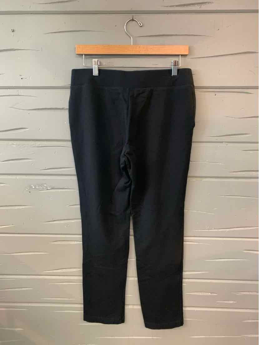 Black slim-fit pants with a mid-rise waist and straight legs hanging on a wooden hanger.