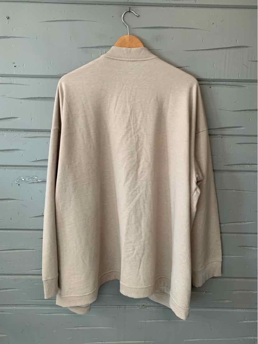 Tan long-sleeve women’s top with a soft knit texture and loose, straight fit, shown from the back.