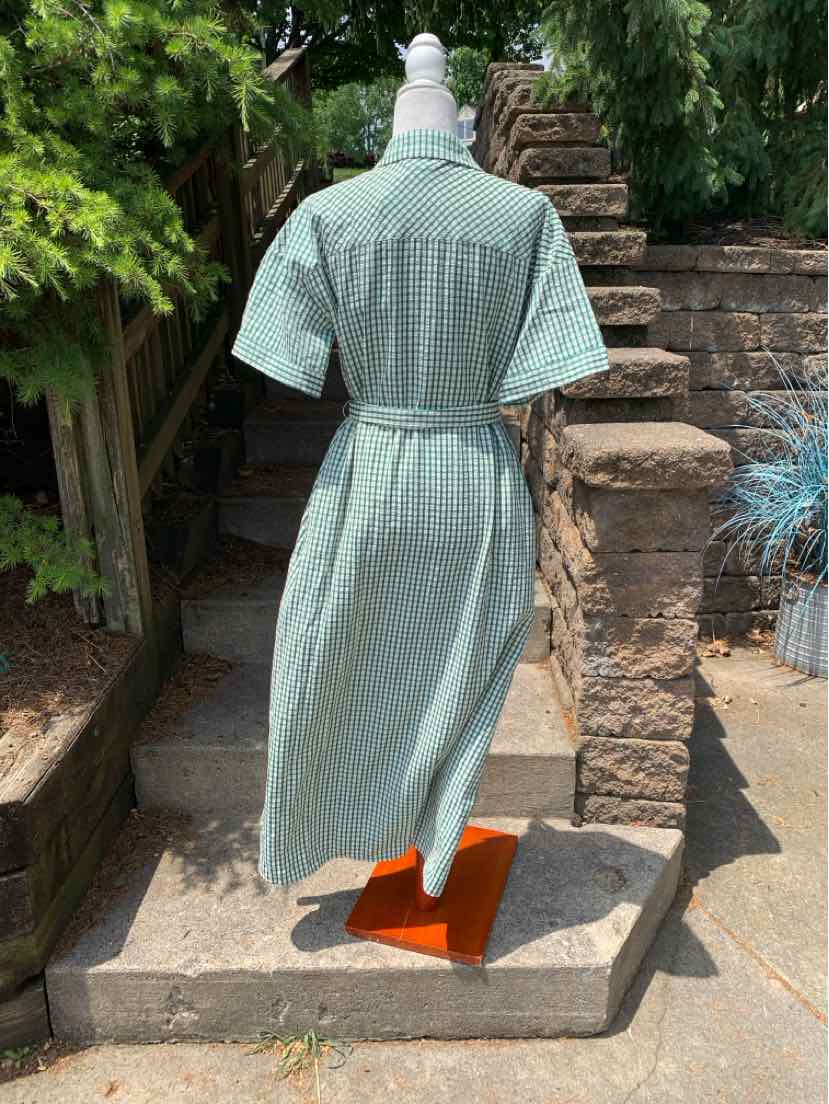 Teal gingham short-sleeve dress with cinched waist and mid-calf length displayed on mannequin outdoors.