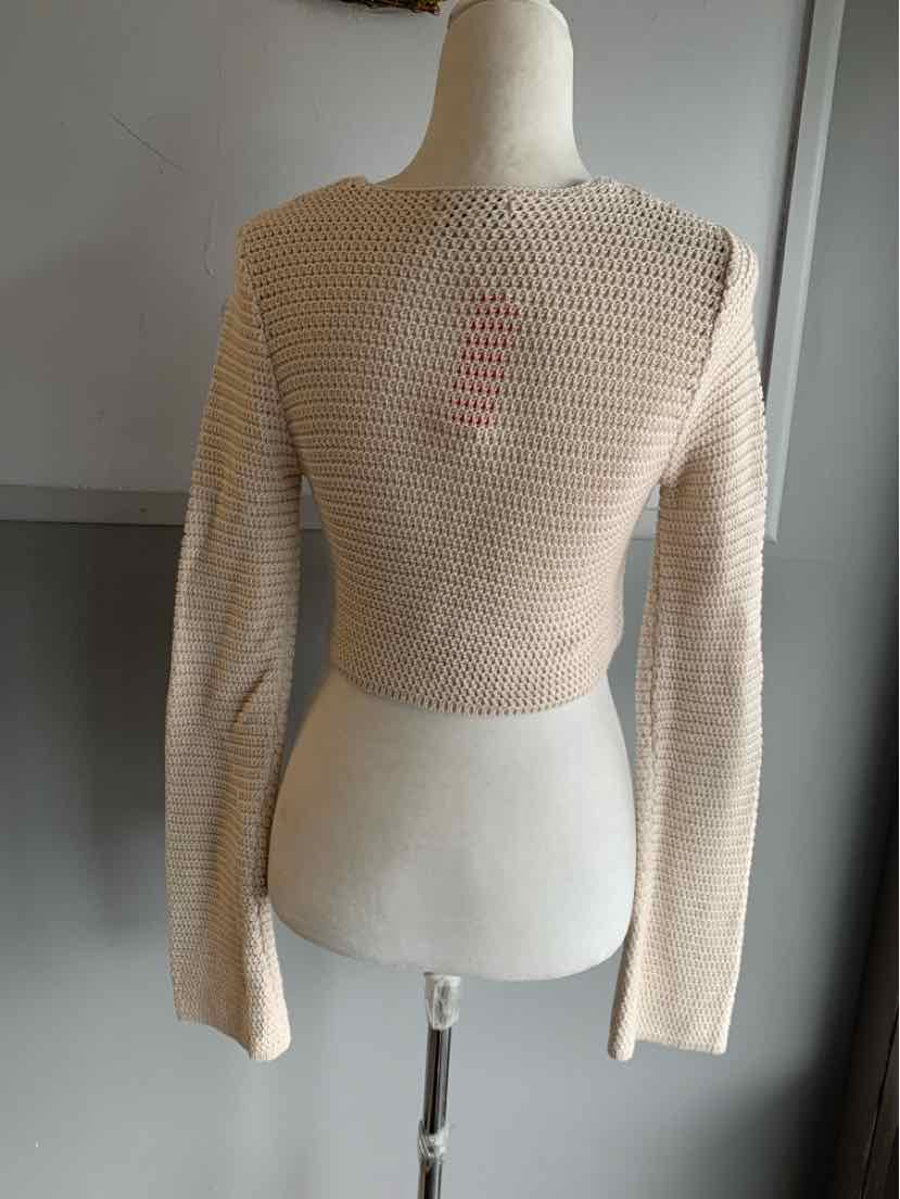 Beige open-knit cropped sweater with long sleeves on a mannequin back view.