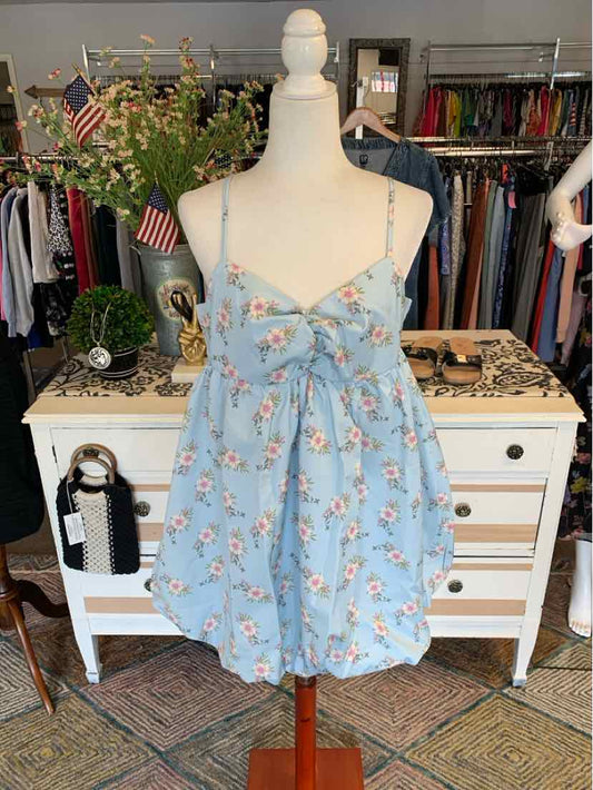 Light blue floral sleeveless dress with spaghetti straps and ruched bust on mannequin.