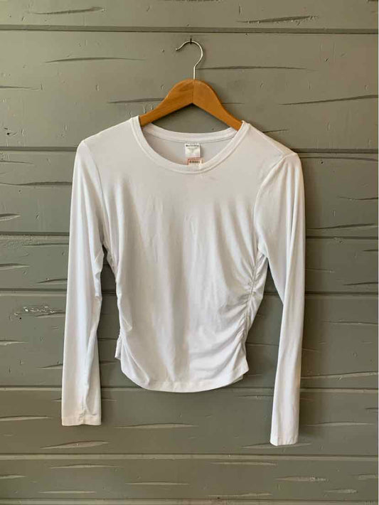 White long-sleeve crewneck athletic shirt with smooth, fitted fabric hanging on wooden hanger.