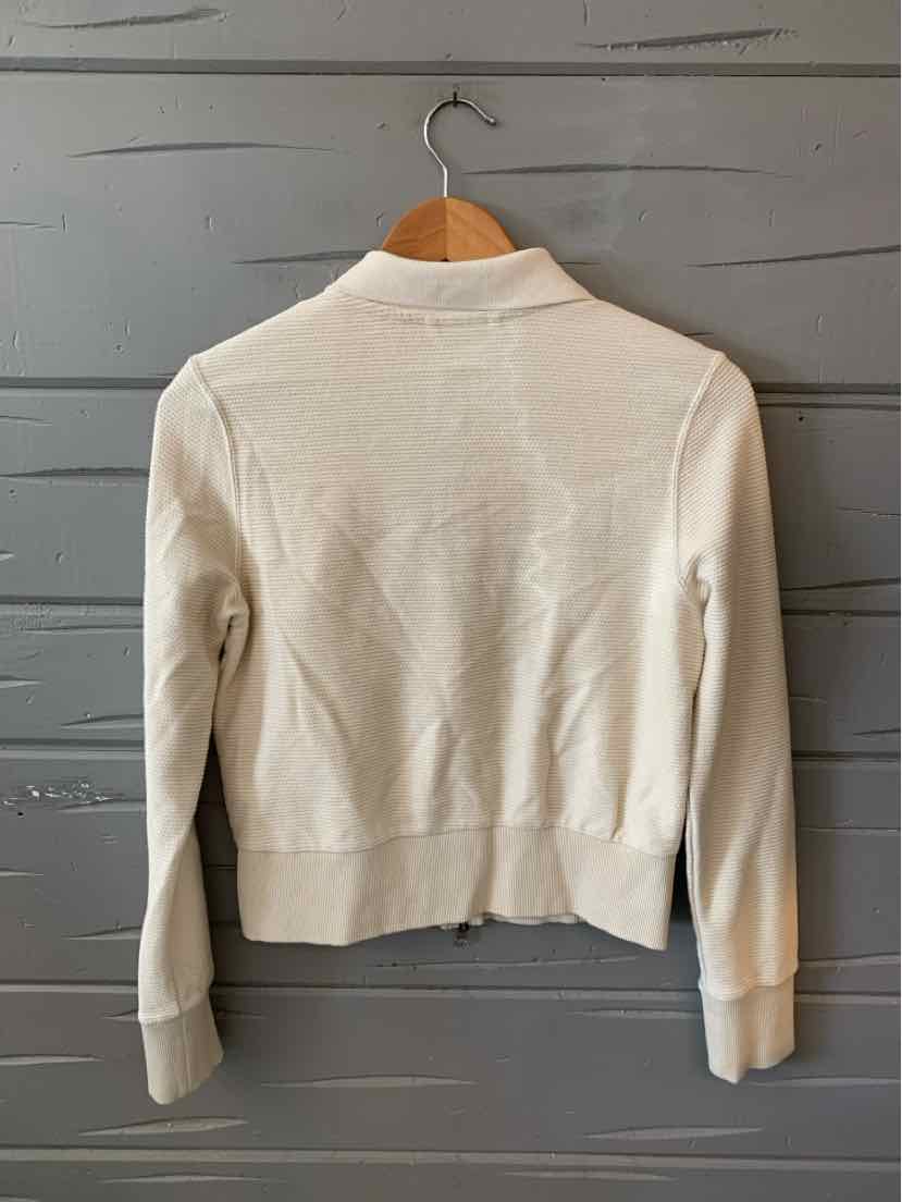 Off-white lightweight women's jacket with ribbed cuffs and waistband hanging on wooden hanger.