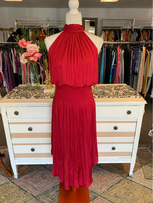 Red sleeveless halter neck dress with pleated fabric and fitted waist displayed on a mannequin.