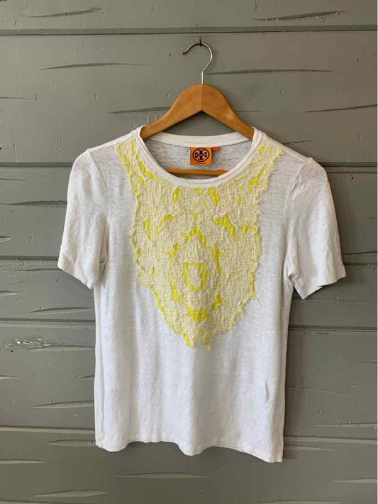 White short-sleeve knit top with yellow floral lace applique on front, crew neckline.