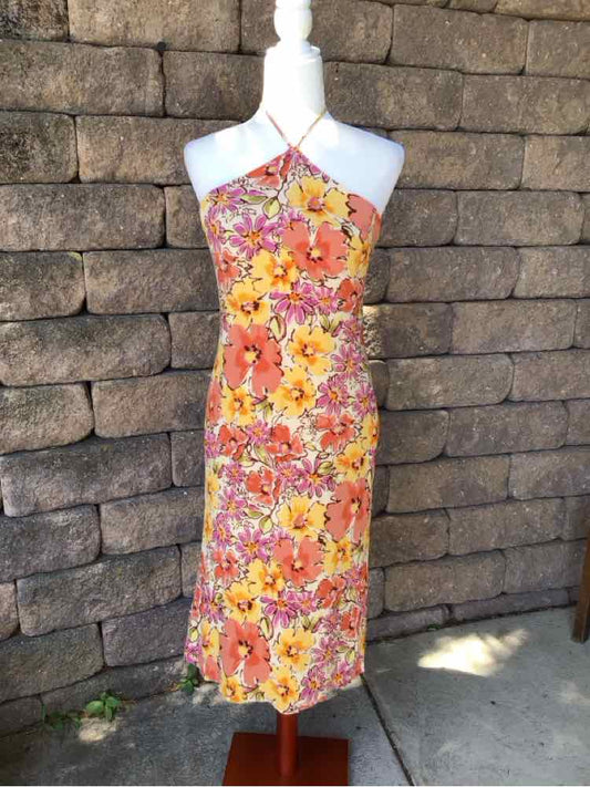 Floral midi dress with halter neckline, fitted silhouette, and bright orange, pink, and yellow flower print.