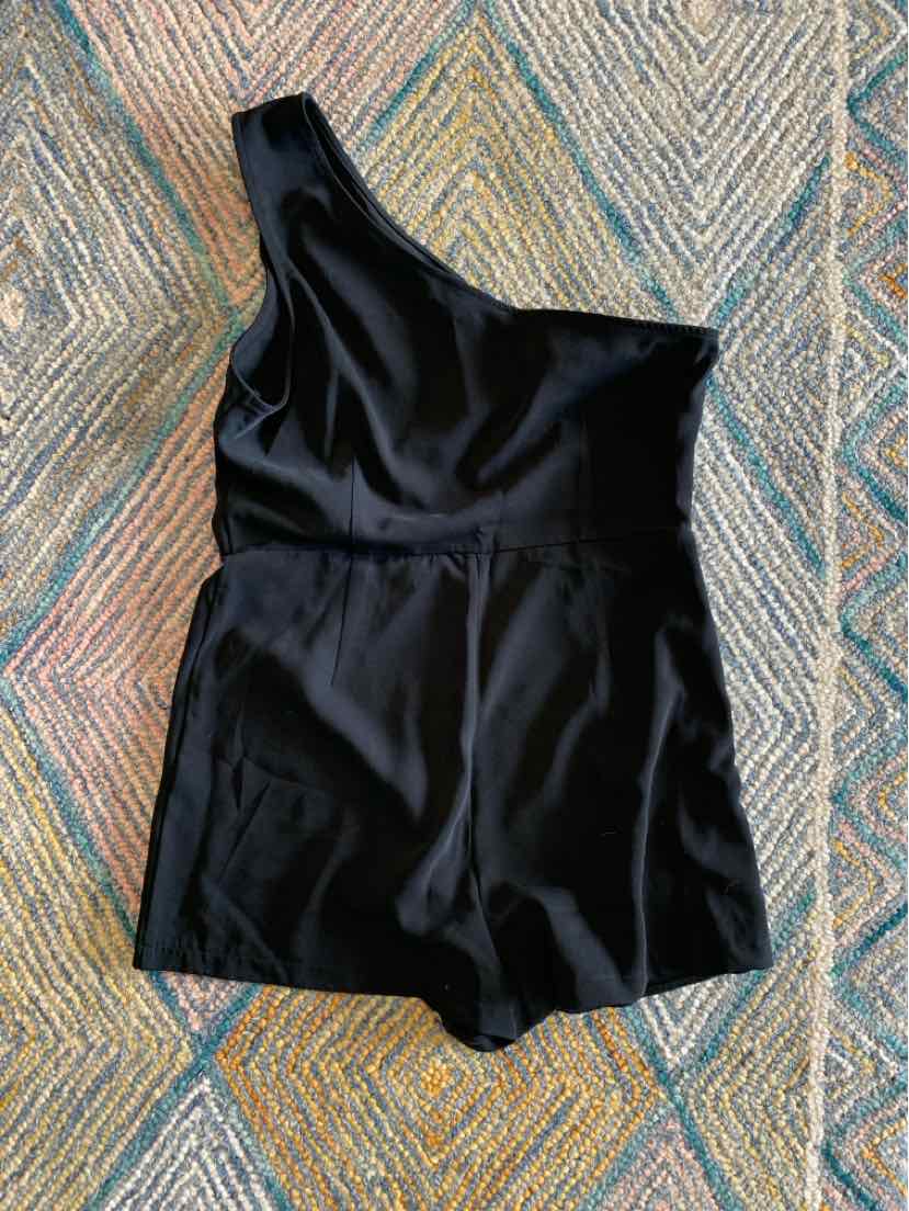 Black one-shoulder sleeveless romper with fitted waist and short-length bottom.