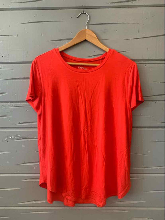 Red short-sleeve relaxed-fit T-shirt with round neckline hanging on wooden hanger.
