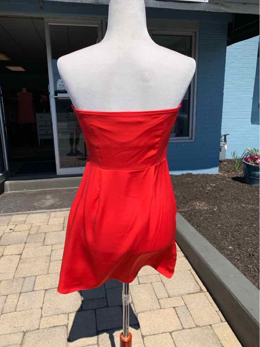 Strapless bright red mini dress with fitted bodice and flared skirt on mannequin.