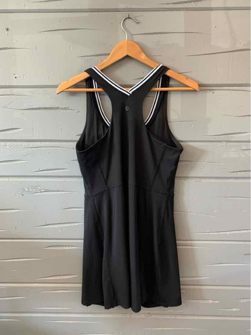 Black sleeveless athletic dress with racerback design and white trim on straps.