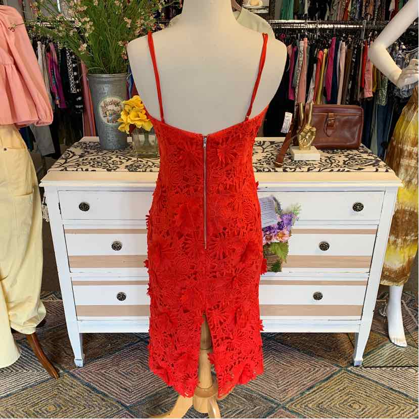 Red lace Bardot dress with spaghetti straps, back zipper, and midi length slit hem.