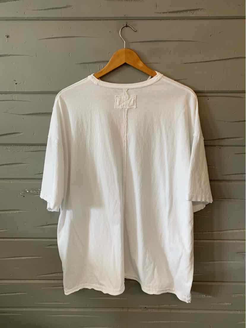 White oversized short-sleeve T-shirt with small embroidered logo on back neckline.