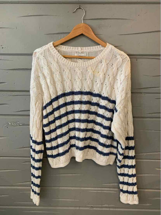 White knit sweater with navy blue horizontal stripes across the midsection and sleeves, ribbed cuffs and hem.