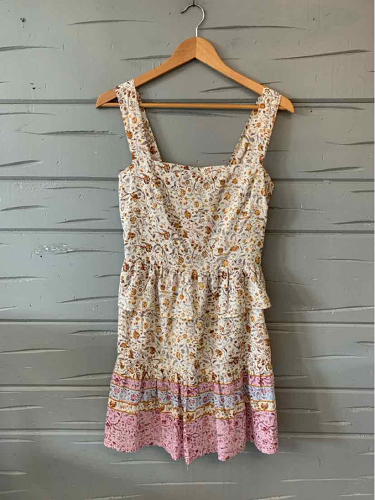 Sleeveless floral dress with gathered waist, square neckline, and pink patterned hem.