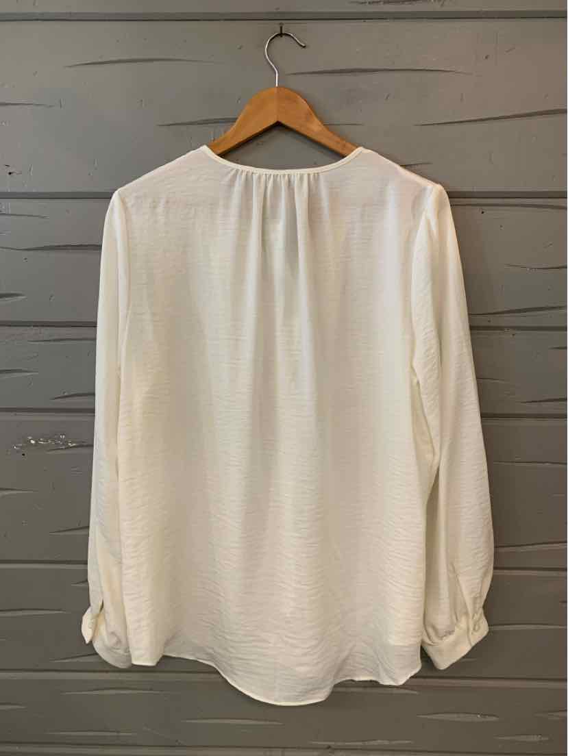 White long-sleeve blouse with soft gathered fabric at the back yoke, relaxed fit, and buttoned cuffs.