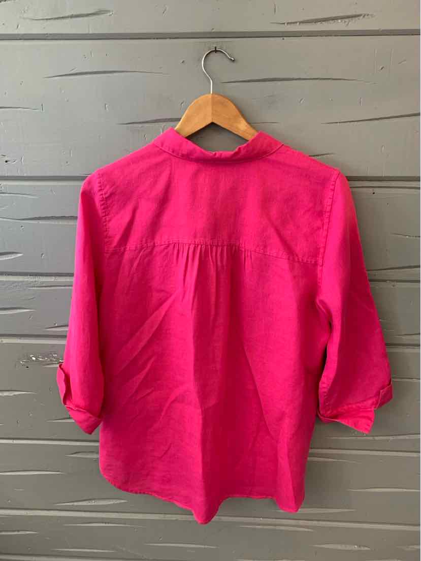 Bright pink long-sleeve blouse with roll-tab sleeves and a relaxed fit hanging on a wooden hanger.