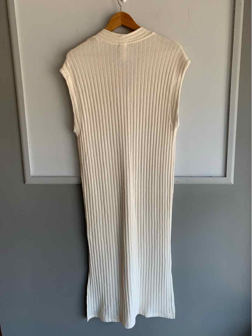 Sleeveless cream ribbed knit midi dress with high neckline hanging on wooden hanger.