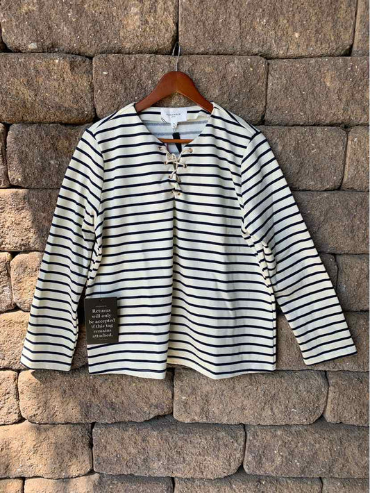 White long-sleeve shirt with black horizontal stripes and round neckline on wooden hanger.