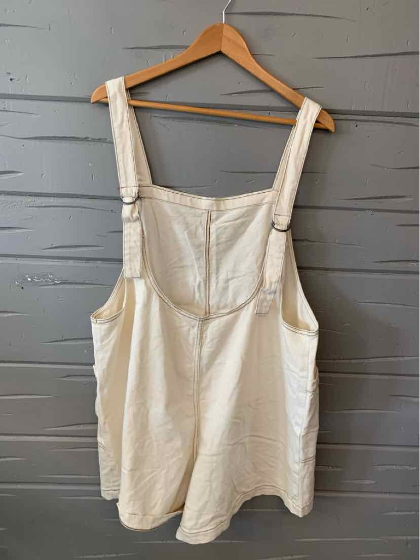 Cream-colored sleeveless overall dress with adjustable straps and front zipper closure.