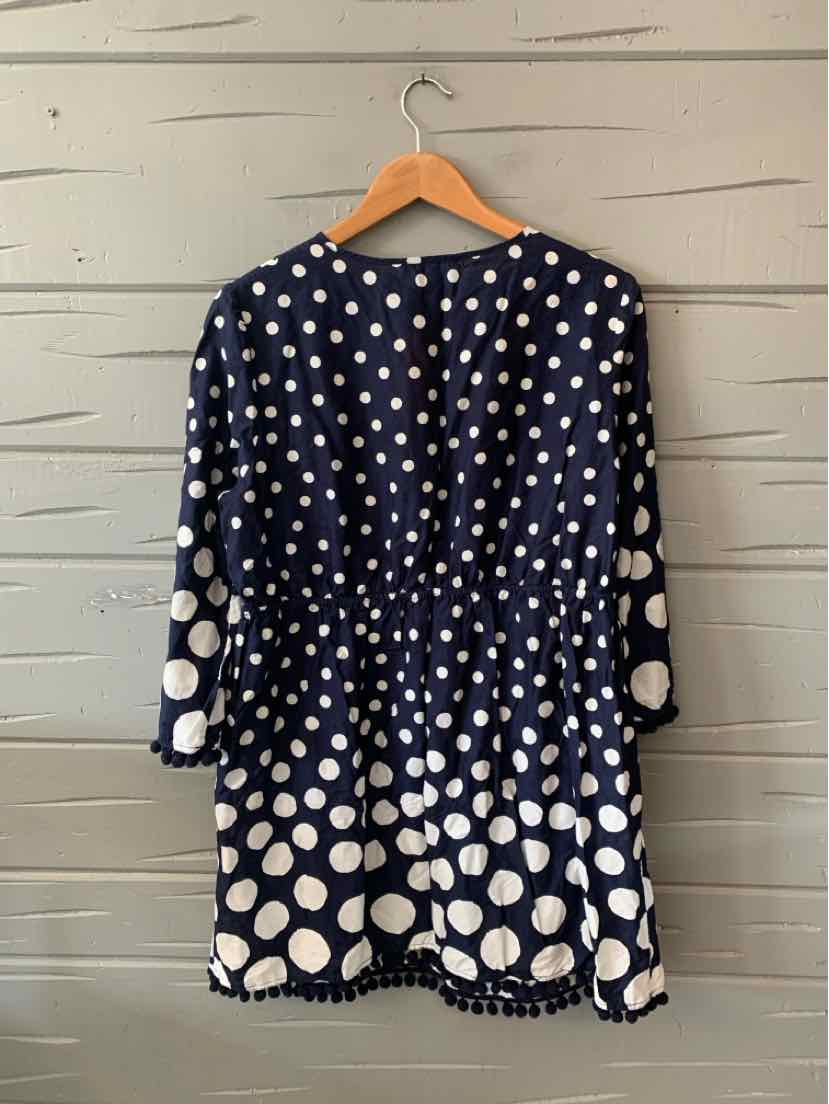 Navy blue dress with white polka dots, long sleeves, gathered waist, and above-knee length.