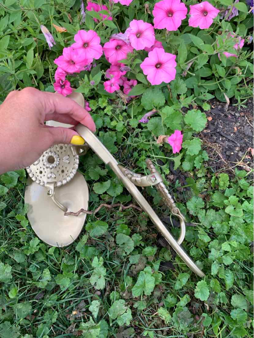 Gold metallic flat sandal with circular braided detail and T-strap design, size 6.