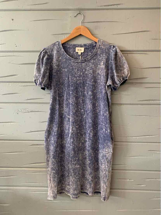 Short-sleeve tie-dye dress in blue with puffed sleeves and relaxed fit hanging on wooden hanger.