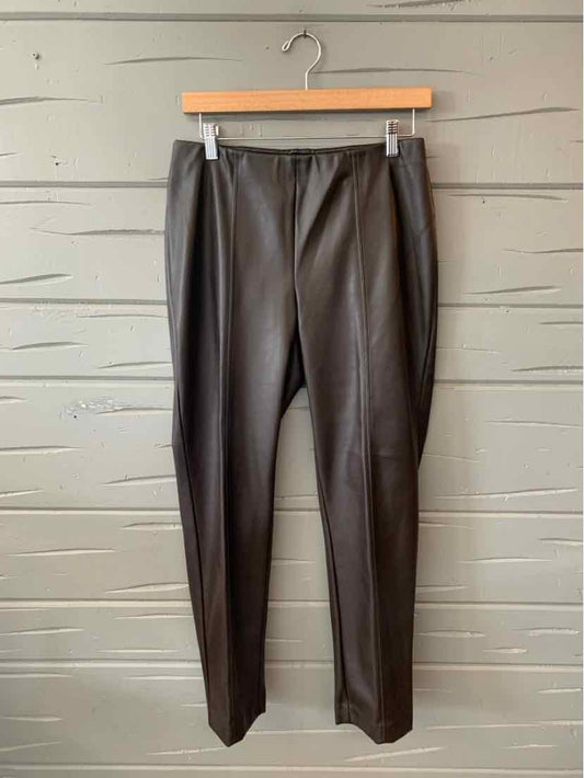 Black faux leather high-waist tapered pants with front pleats hanging on wooden hanger.