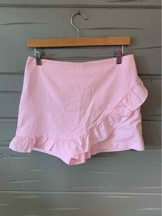Light pink wrap skirt with ruffled hem detail in a size 4, hanging on wooden hanger.