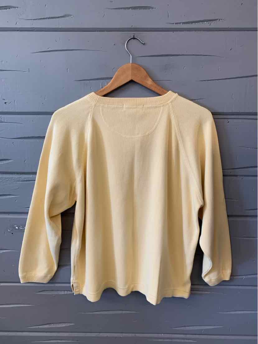 Pale yellow Eddie Bauer pullover sweater with a crew neckline, long sleeves, and a softly scalloped hem.