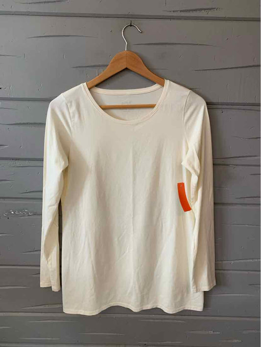 Long-sleeve cream-colored cotton top with scoop neckline and slim fit on wooden hanger.