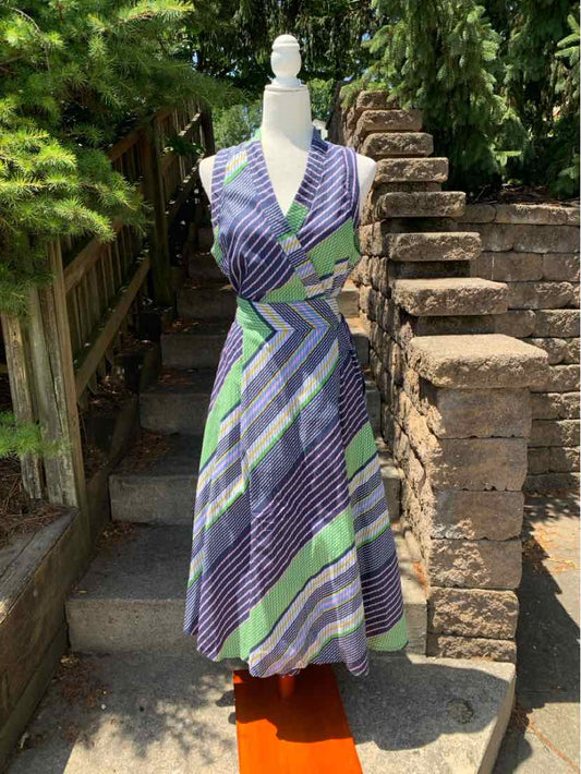 Sleeveless midi dress with diagonal stripes in navy, white, and green, featuring a V-neck and fitted waist.