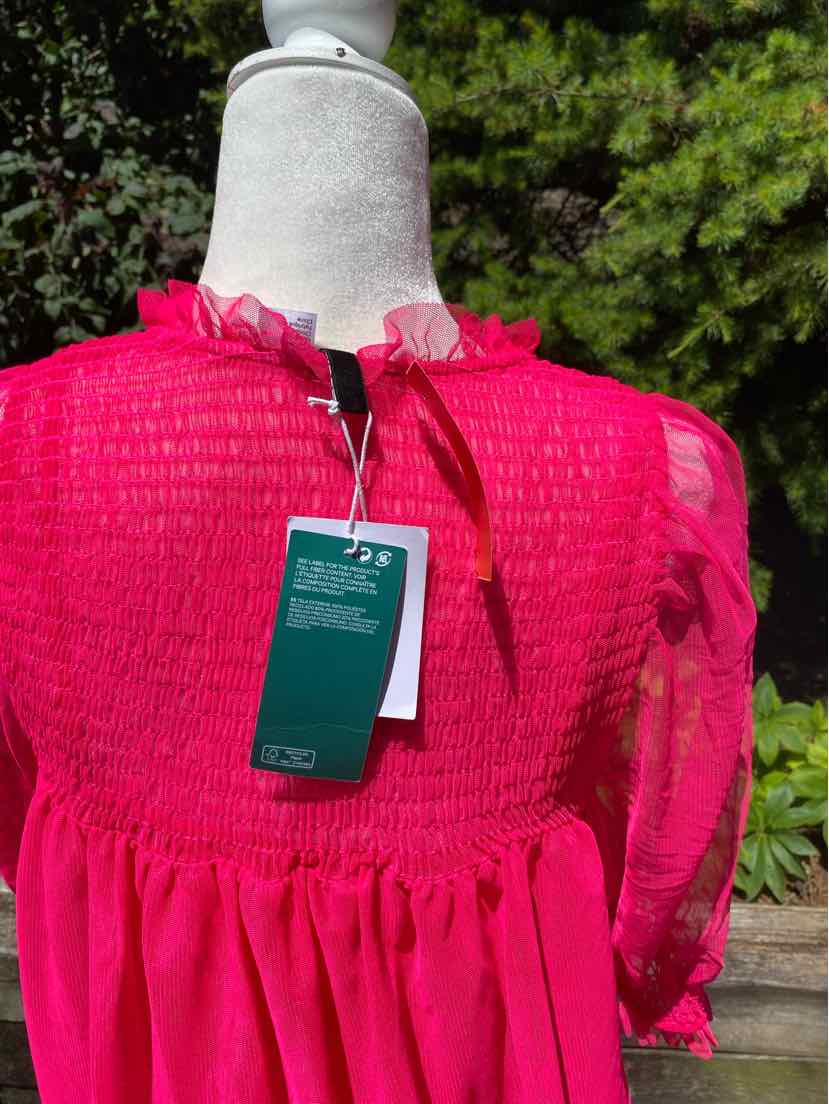 Pink lightweight dress with ruched bodice and sheer puff sleeves on mannequin outdoors.