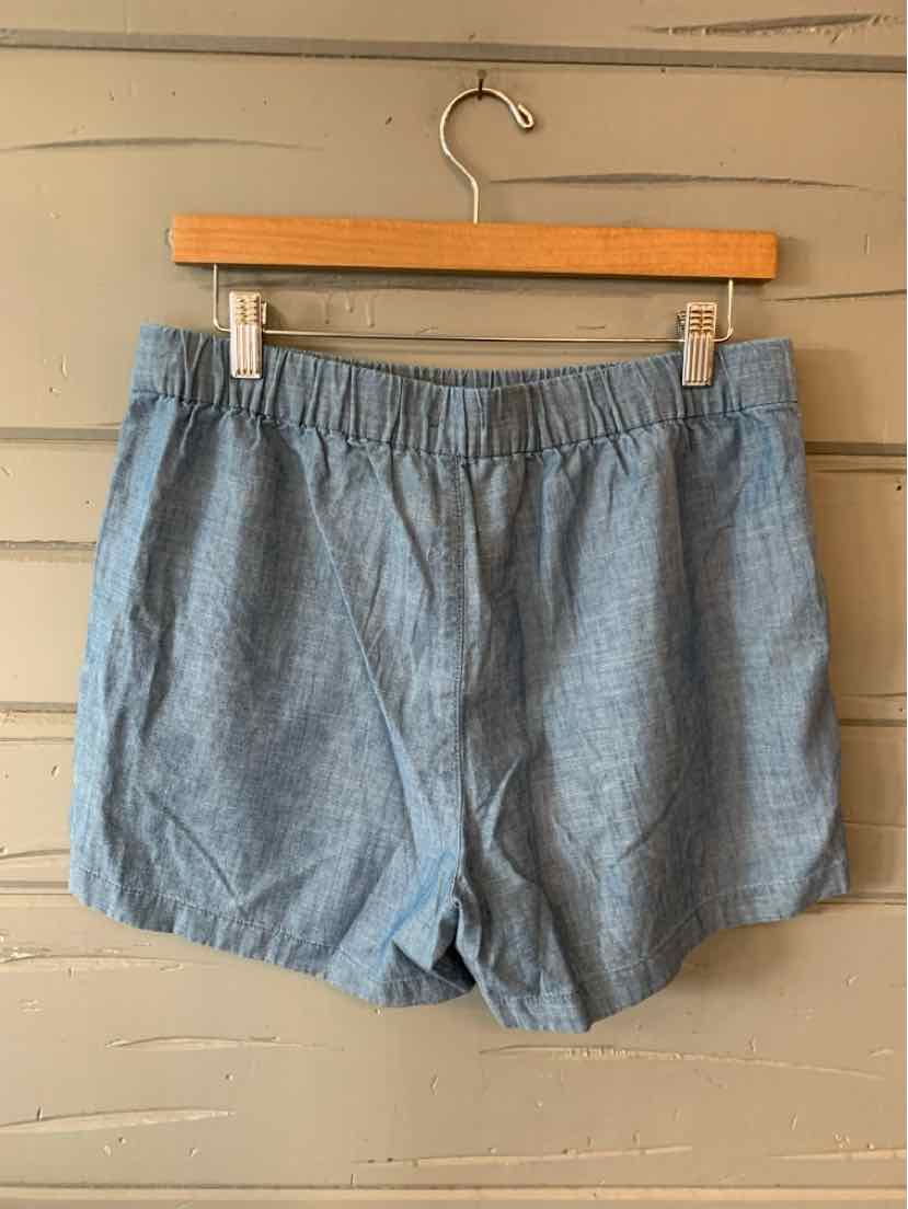 Light blue cotton blend shorts with elastic waistband and relaxed fit hanging on wooden hanger.