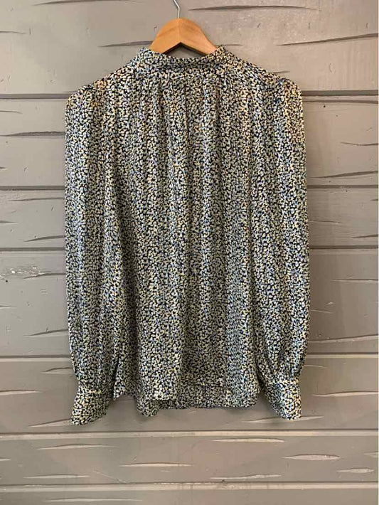 Long-sleeve blouse with blue floral print on white fabric and gathered cuffs.