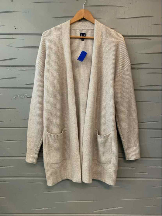 Beige knit GAP cardigan with an open front, long sleeves, and two patch pockets.