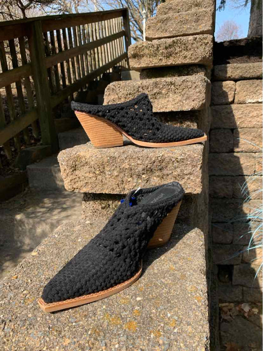 Black woven mule shoes with tan wooden stacked heels and pointed toes, size 9.