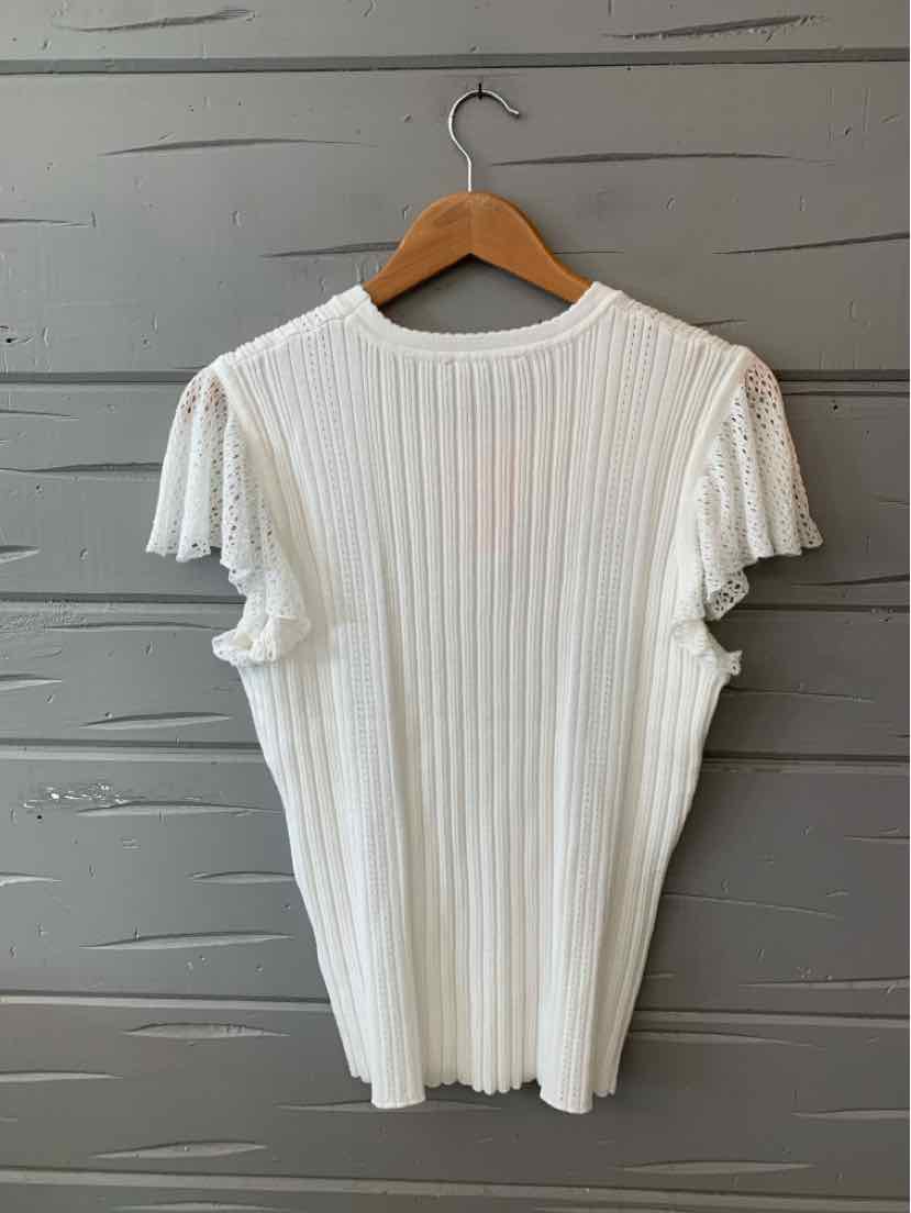 White ribbed knit short-sleeve top with slightly ruffled cuffs on a wooden hanger.