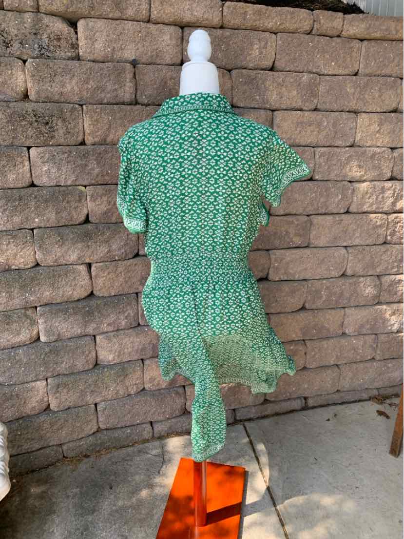 Green floral short-sleeve maxi dress with cinched waist and ruffled hem on white mannequin.