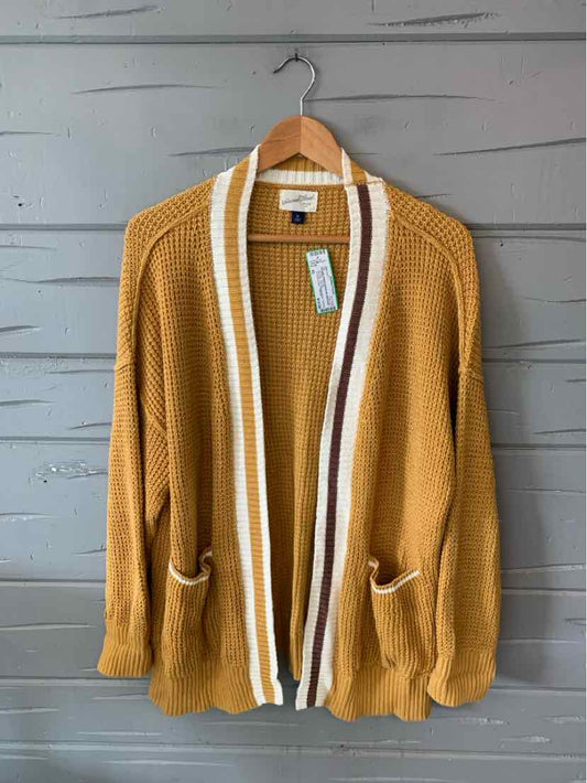 Mustard yellow knit cardigan with white and brown striped trim, open front, and two front pockets.