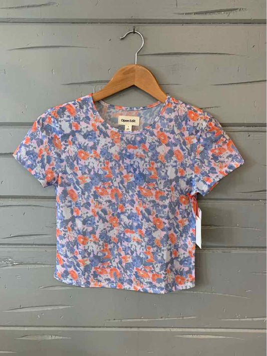 Short-sleeve cropped top with multi-color floral print in blue, orange, and white.