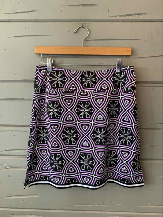 Black and purple patterned golf skort with geometric design in size small hanging on wooden hanger.