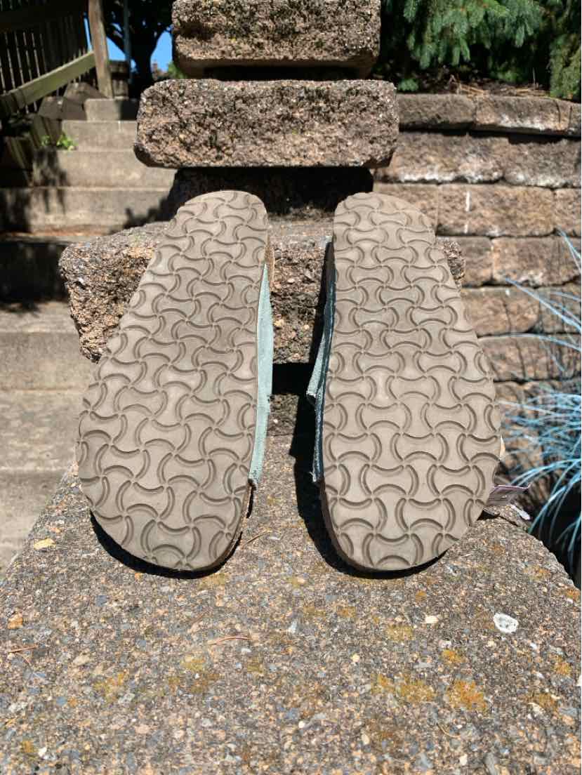 Pair of well-worn beige rubber-soled sandals with distinctive wavy tread pattern, size 40.