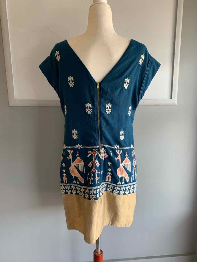 Blue and beige sleeveless dress with deep V-neck, button front, floral and tribal embroidery.