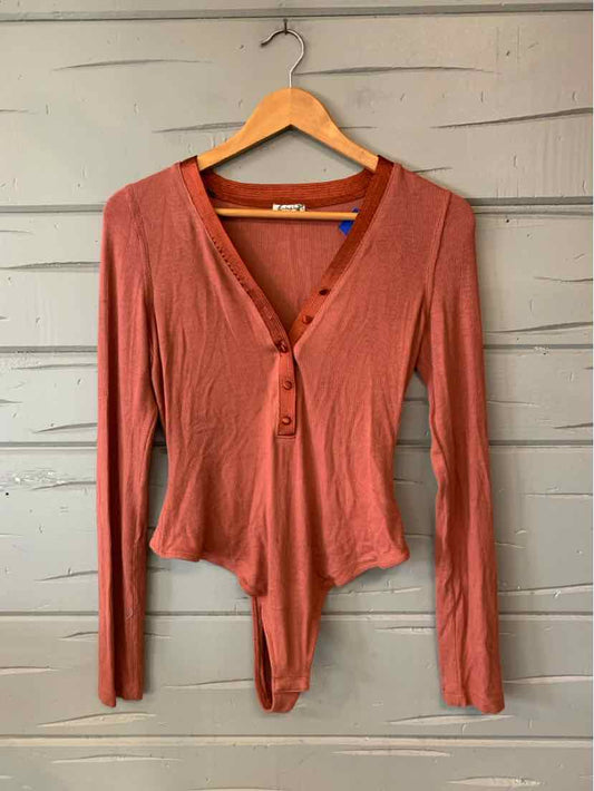 Rust-colored long-sleeve Free People top with a V-neck, front button closure, and fitted waist.