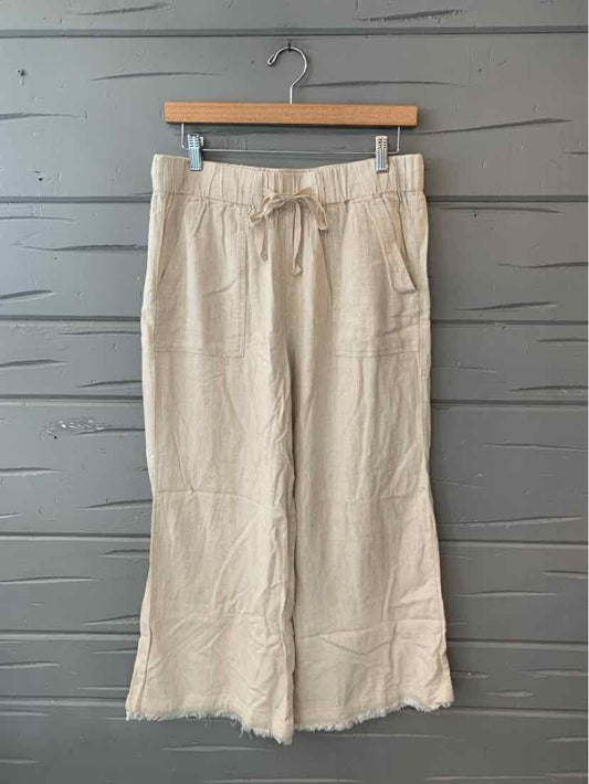Beige casual wide-leg pants with drawstring waist and front patch pockets.