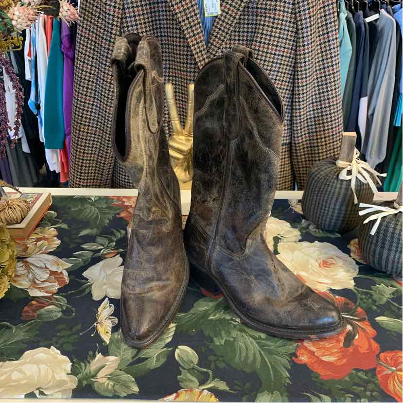 Worn brown leather cowboy boots with pointed toes and scalloped top edges, size 7.