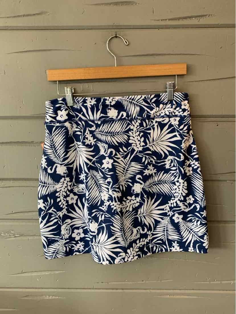Navy blue skirt with white tropical leaf print, front pleats, and a high waist.