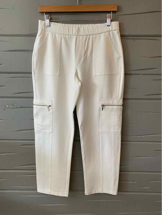 White cropped pants with elastic waistband and front zipper pocket details.