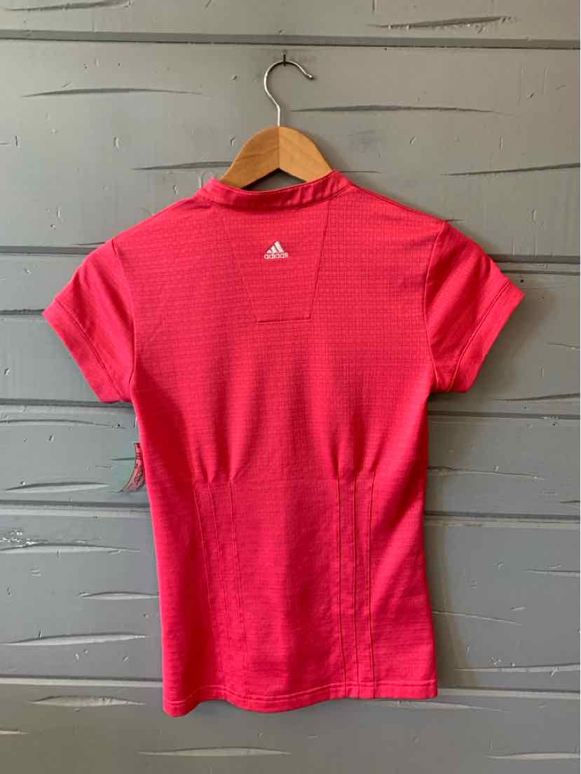 Women's bright pink Adidas short-sleeve performance shirt with subtle textured pattern and white logo on upper back.