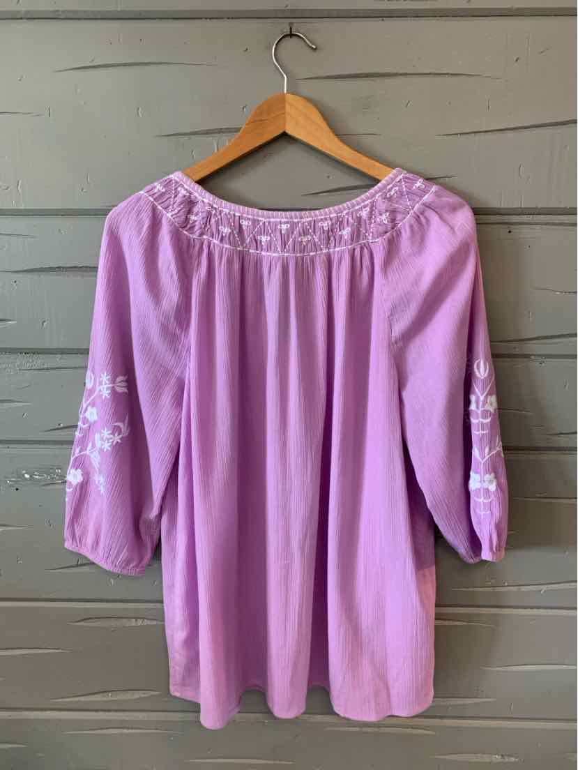 Lavender blouse with embroidered neckline and 3/4 sleeves on wooden hanger.